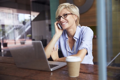 Smiling woman at her desk talking on the phone